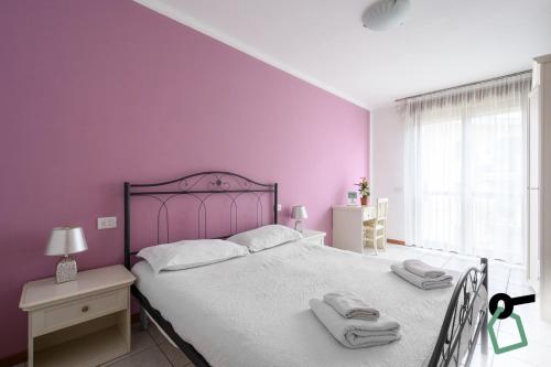 een slaapkamer met een groot bed met paarse muren bij HOTIDAY Residence Garda in Peschiera del Garda