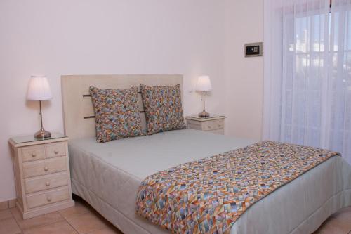 a bedroom with a bed with two night stands and two lamps at Vila Rosal Margarida Apartment in Albufeira