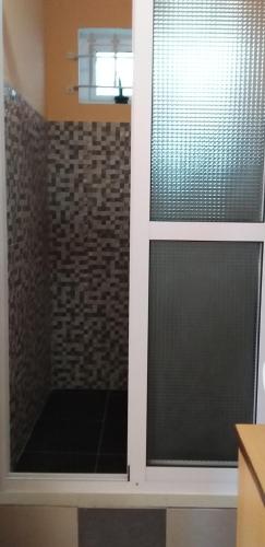 a window in a bathroom with a brick wall at Flamengo in Pereybere