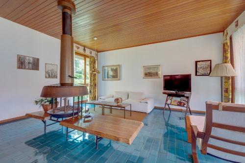 a living room with a couch and a tv at Villa Olivella in Sale Marasino