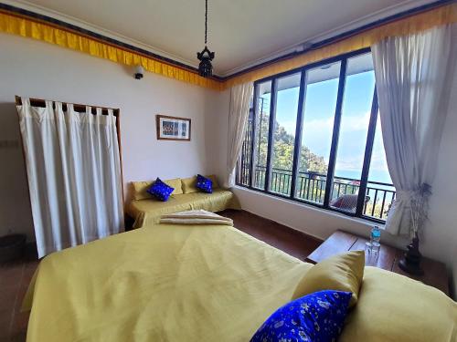a bedroom with two beds and a large window at Peace Dragon Lodge in Pokhara