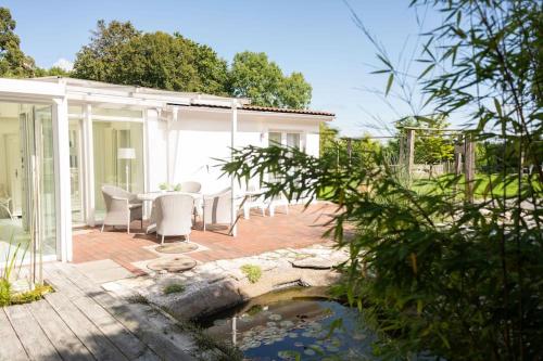 a house with a patio with a pond at Meer Weiss in Wangerland