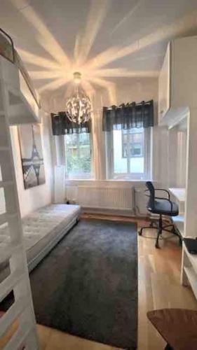 - un salon avec une chaise et un lustre dans l'établissement Cozy Cottage In Central Gothenburg, à Göteborg