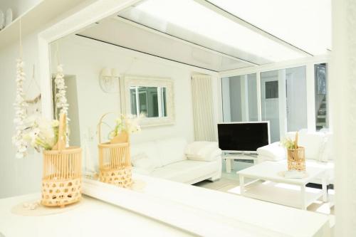 a white living room with a large mirror at Meer Weiss in Wangerland