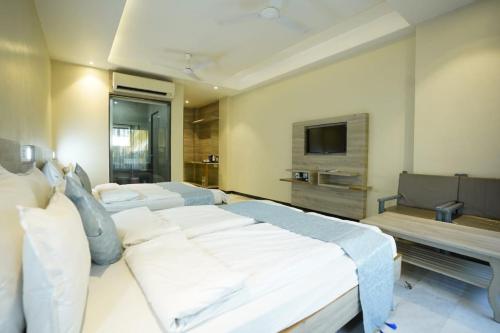 a large bedroom with a large bed and a tv at Hotel Hrushikesh in Shirdi