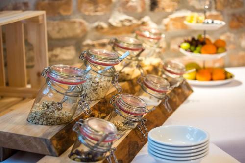 a table with jars of food and plates of fruit at Pension Zum Schrammel in Altdorf bei Nuernberg