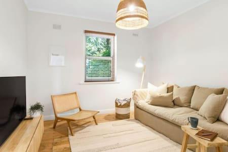 a living room with a couch and a chair at Rossini's Cottage - Hills Escape in Mount Lofty