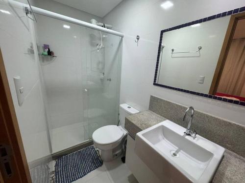 uma casa de banho com um WC, um lavatório e um chuveiro em Itaparica Beach Lindo Pé na Areia 02 Qtos Praia de Itaparica em Vila Velha