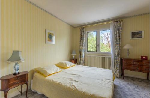 1 dormitorio con cama, mesa y ventana en Cosy T3 - Jardin - Parking - Piscine, en Montpellier