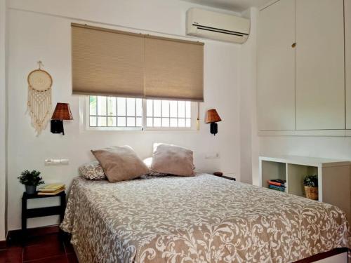 a bedroom with a bed with two pillows and a window at Estudio Morera in Málaga
