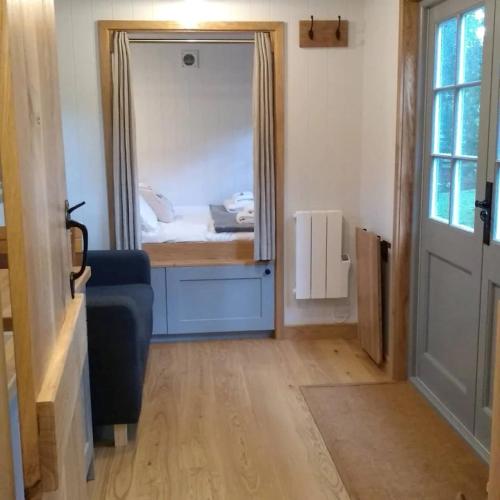 Ashurst的住宿－Finest Retreats - The Bakers Hut，一间带镜子的卧室和一张位于客房内的床