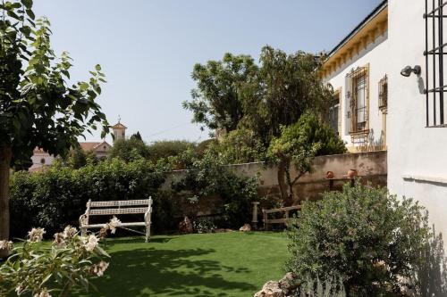 a garden with two benches in a yard at Estudio Morera in Málaga