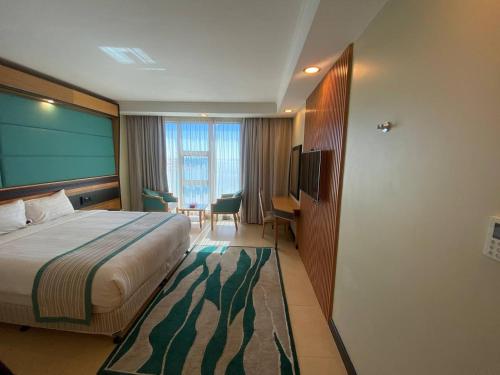 Nooh Apartment في Al Ḩadd: غرفة فندقية بسرير وطاولة وكراسي