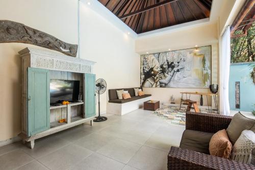 a living room with a fireplace and a couch at Enigma Villa Canggu in Canggu