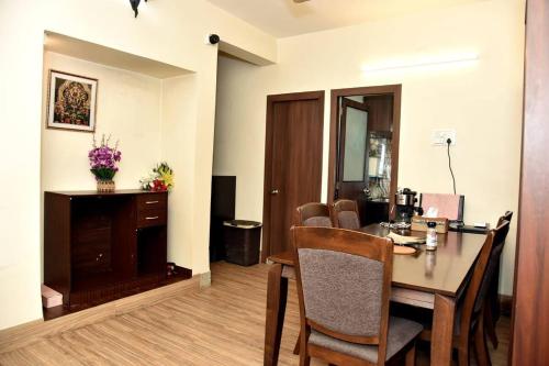 Cette chambre comprend un bureau et une table avec des chaises. dans l'établissement Orchid B&B, à Kolkata