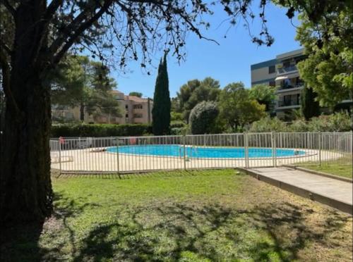 une clôture autour d'une piscine dans un parc dans l'établissement Cosy T3 - Jardin - Parking - Piscine, à Montpellier