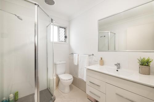 a bathroom with a toilet and a sink and a shower at Air Con! Laundry! Stylish! in Brisbane