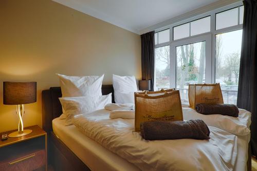 1 dormitorio con 2 camas con almohadas blancas y ventana en Schloßappartements Heringsdorf, en Heringsdorf
