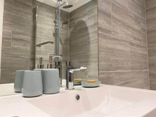 Modern Stylish 2 bedroom 2 Bath Apartments in Rochester by 360Stays في روتشستر: وجود مغسلة بيضاء في الحمام مع دش
