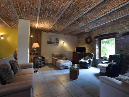 a living room with couches and a stone wall at Libramont Stone Garden Haven in Libramont