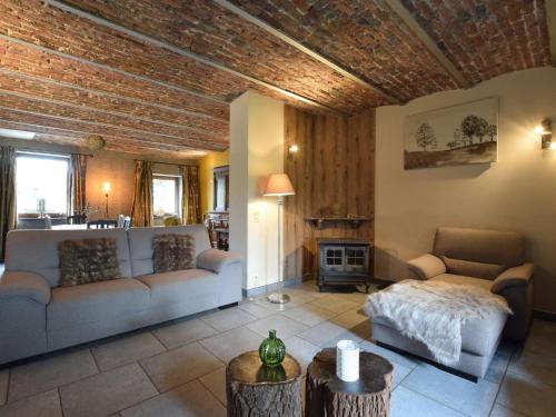 sala de estar con sofá y chimenea en Holiday home in the heart of the Ardennes, en Libramont