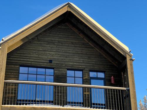 a house with two windows and a balcony at Ljungvind Funäsdalen in Funäsdalen
