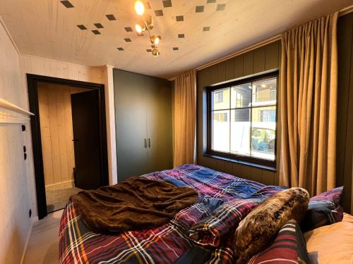 a bedroom with a bed with a comforter and a window at Ljungvind Funäsdalen in Funäsdalen
