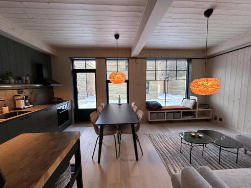 a kitchen and living room with a table and chairs at Ljungvind Funäsdalen in Funäsdalen