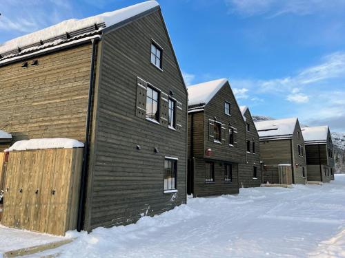 a row of houses in the snow with snow at Ljungvind Funäsdalen in Funäsdalen