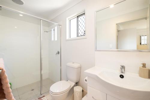 a bathroom with a toilet and a sink and a shower at Aircon! Parking! Host with 100s of 5 star reviews! in Brisbane
