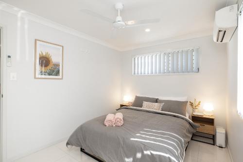 a bedroom with a bed with pink shoes on it at Aircon! Parking! Host with 100s of 5 star reviews! in Brisbane