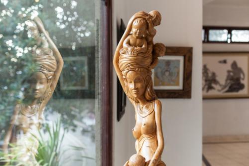 a statue of a woman holding a child on top of a window at Dewangga Ubud in Ubud