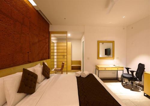 a bedroom with a bed and a desk in a room at Avocado Cottages in Suntikoppa