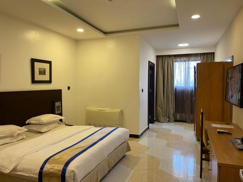 a bedroom with a large bed and a desk at Hotel 5092 in Abuja