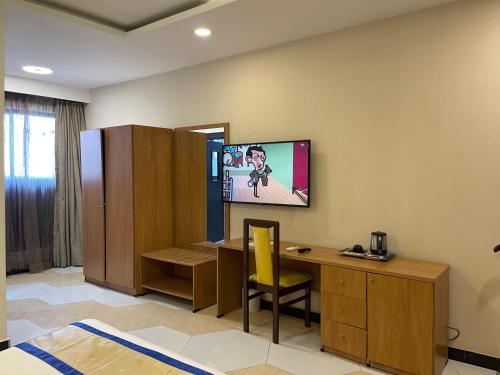 a room with a desk and a tv on the wall at Hotel 5092 in Abuja