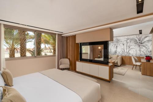 um quarto com uma cama branca e uma grande janela em Kenzi Rissani em Errachidia