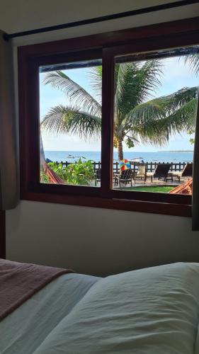 a bedroom with a window looking out at the beach at Kaapalua in Porto De Galinhas