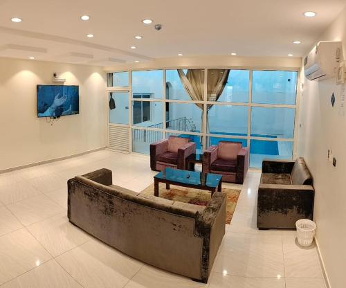 uma sala de estar com um sofá e duas cadeiras em منتجع الكناري للفلل الفندقية الفاخرة Canary resort em Taif