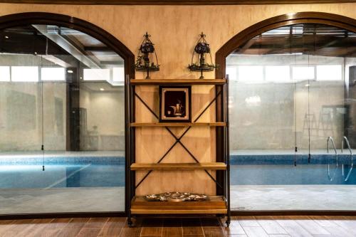 a room with a swimming pool and a shelf with a clock at مزرعة واستراحة ألفي الترفيهية بالهير in Al Qaia