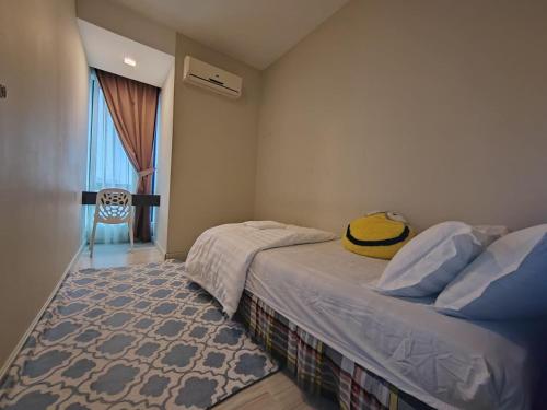 a bedroom with a bed with a yellow hat on it at Ber-Santai @Sky Hotel Suites in Kota Kinabalu