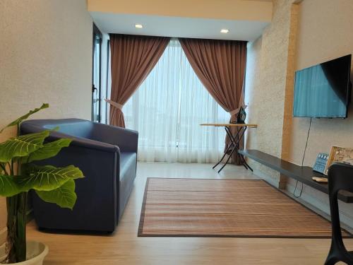 a living room with a couch and a large window at Ber-Santai @Sky Hotel Suites in Kota Kinabalu