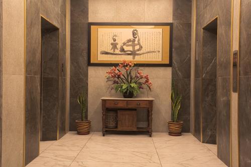 a hallway with a table with a vase of flowers at Ber-Santai @Sky Hotel Suites in Kota Kinabalu