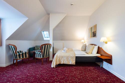 a hotel room with a bed and two chairs at Milling Hotel Park in Middelfart