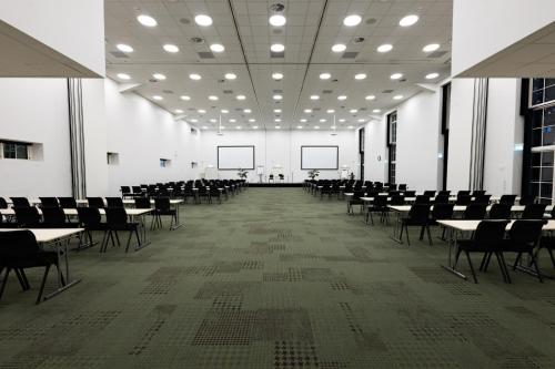 an empty room with tables and chairs in a building at Milling Hotel Park in Middelfart