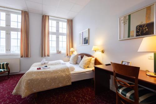 a hotel room with a bed and a desk at Milling Hotel Park in Middelfart