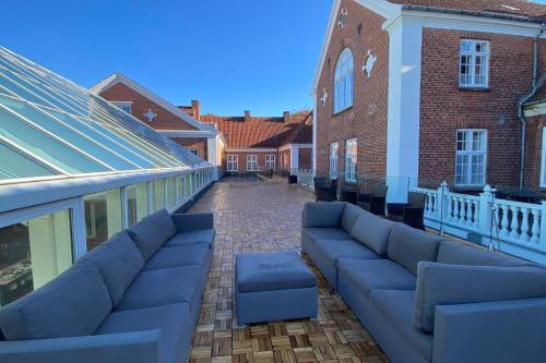 a couch sitting on the patio of a building at Milling Hotel Park in Middelfart