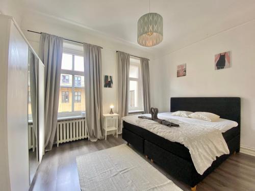 a bedroom with a large bed and two windows at Cozy Apartment In The Heart Of Gothenburg in Gothenburg