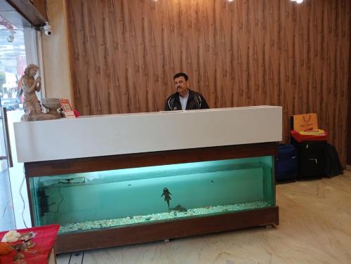 a man standing next to a large fish tank at Hotel Sun Beam Near Gwalior Railway Station in Gwalior