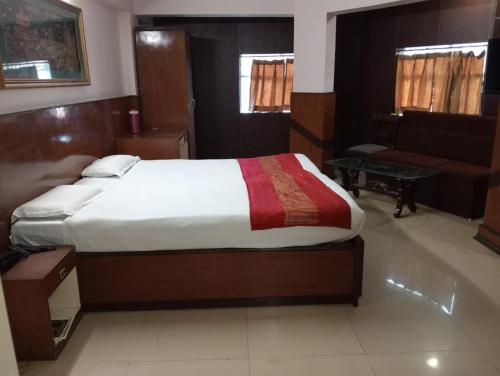 a bedroom with a large bed and a couch at Hotel Sun Beam Near Gwalior Railway Station in Gwalior