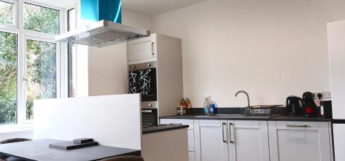 a kitchen with white cabinets and a stove top oven at Alban Suites in Saint Albans